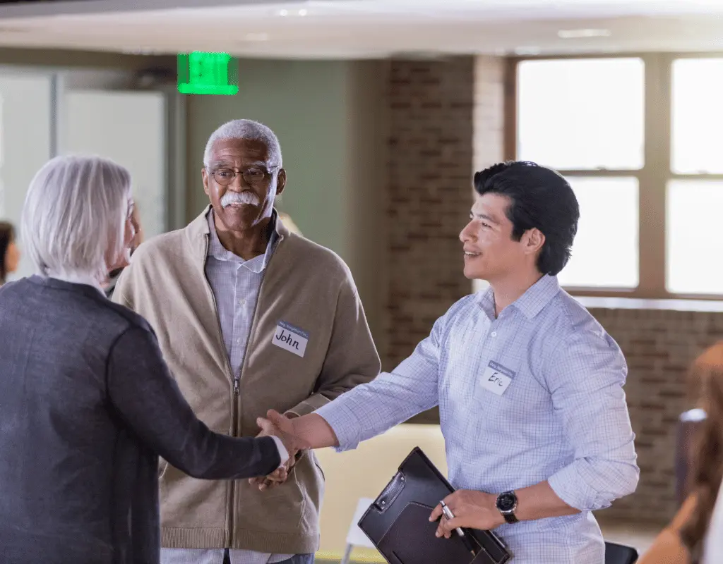 Community members shaking hands and wearing name tags at a condominium homeowners association meeting in Columbus, OH